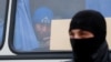 Migrant worker looks out of a police vehicle during a raid carried out by Kaliningrad Federal Migration Service officers looking for immigrants who violate the law