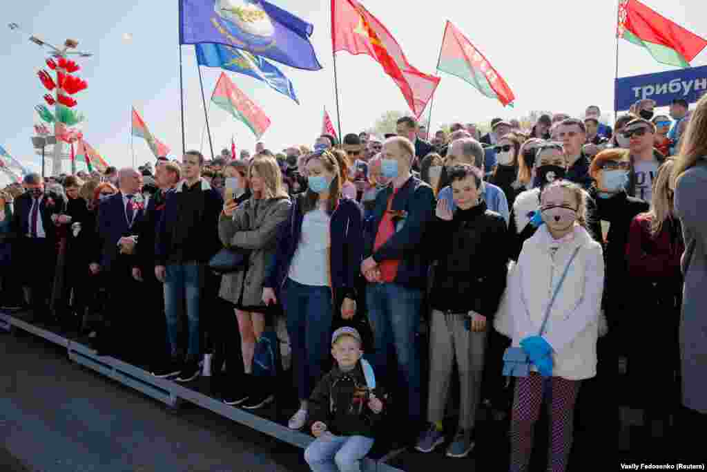 Плакатов с просьбой соблюдать дистанцию ​​и носить маски на параде не было: люди на трибунах и рядом с ними стояли очень плотно